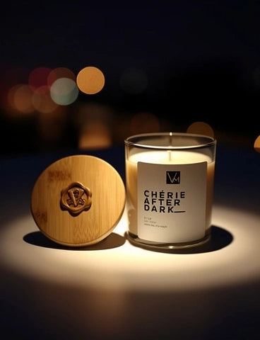 Candle labeled 'Chérie After Dark' with a wooden lid on a dark background