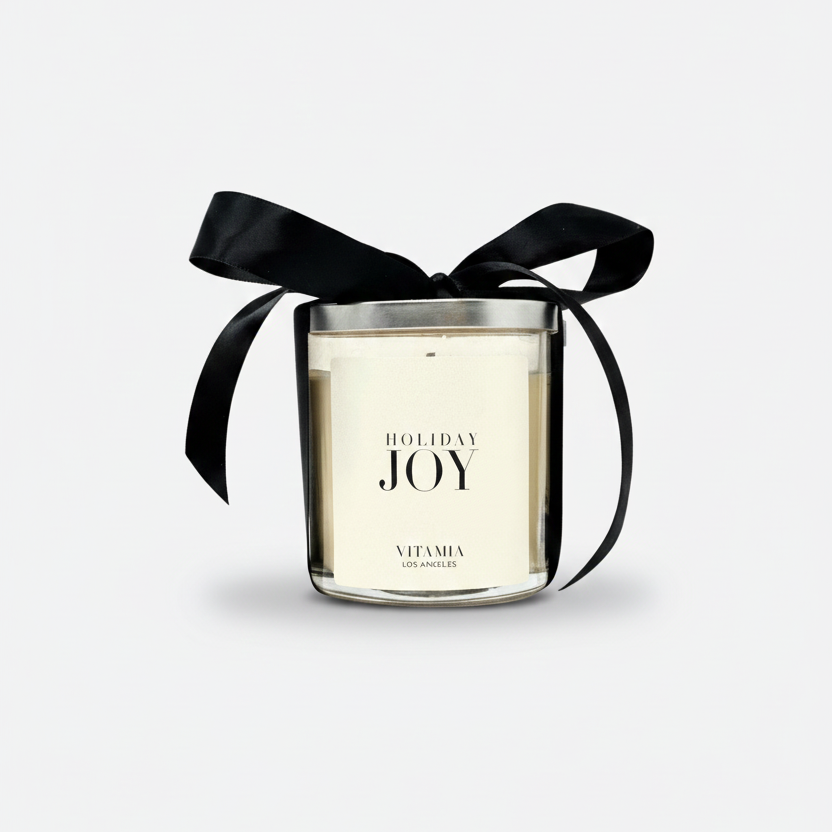 Candle labeled 'Holiday Joy' with a black ribbon on a light gray background