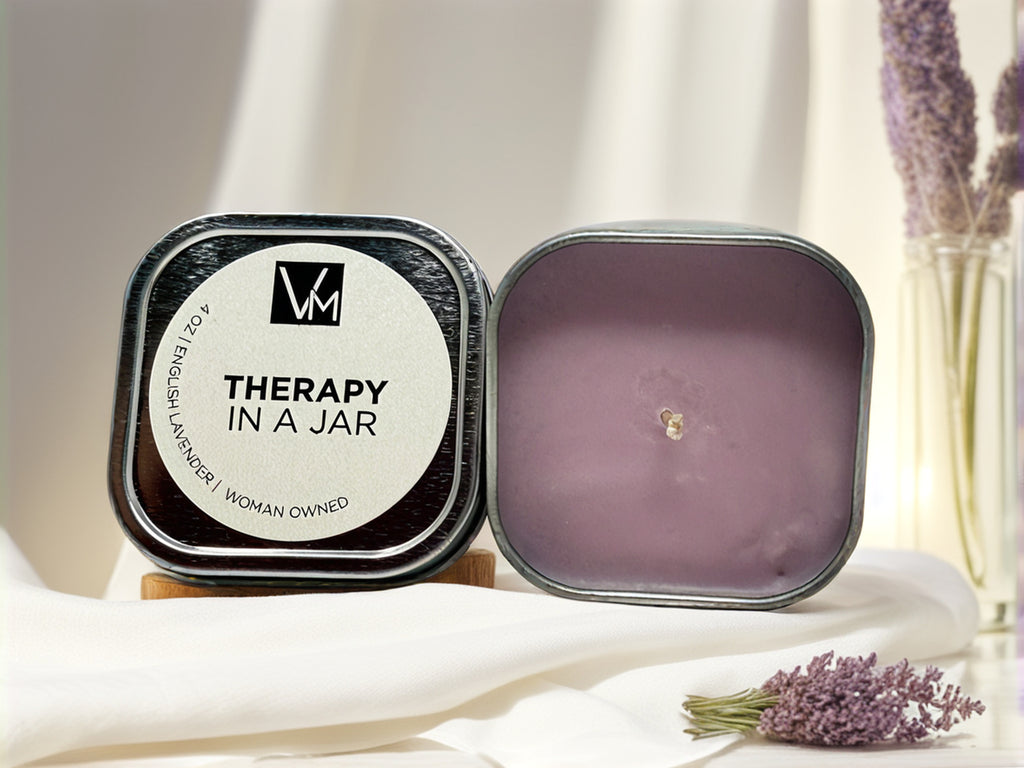 Candle in a jar labeled 'Therapy in a Jar' with lavender flowers in the background